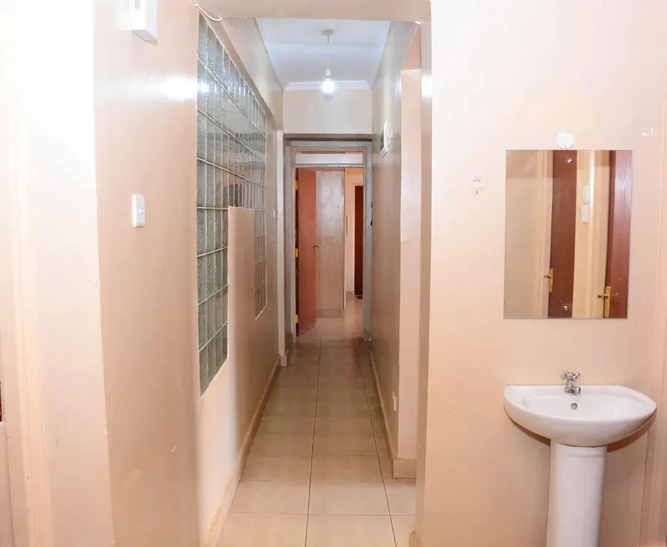 Long corridor with pedestal sink and storage grid on wall
