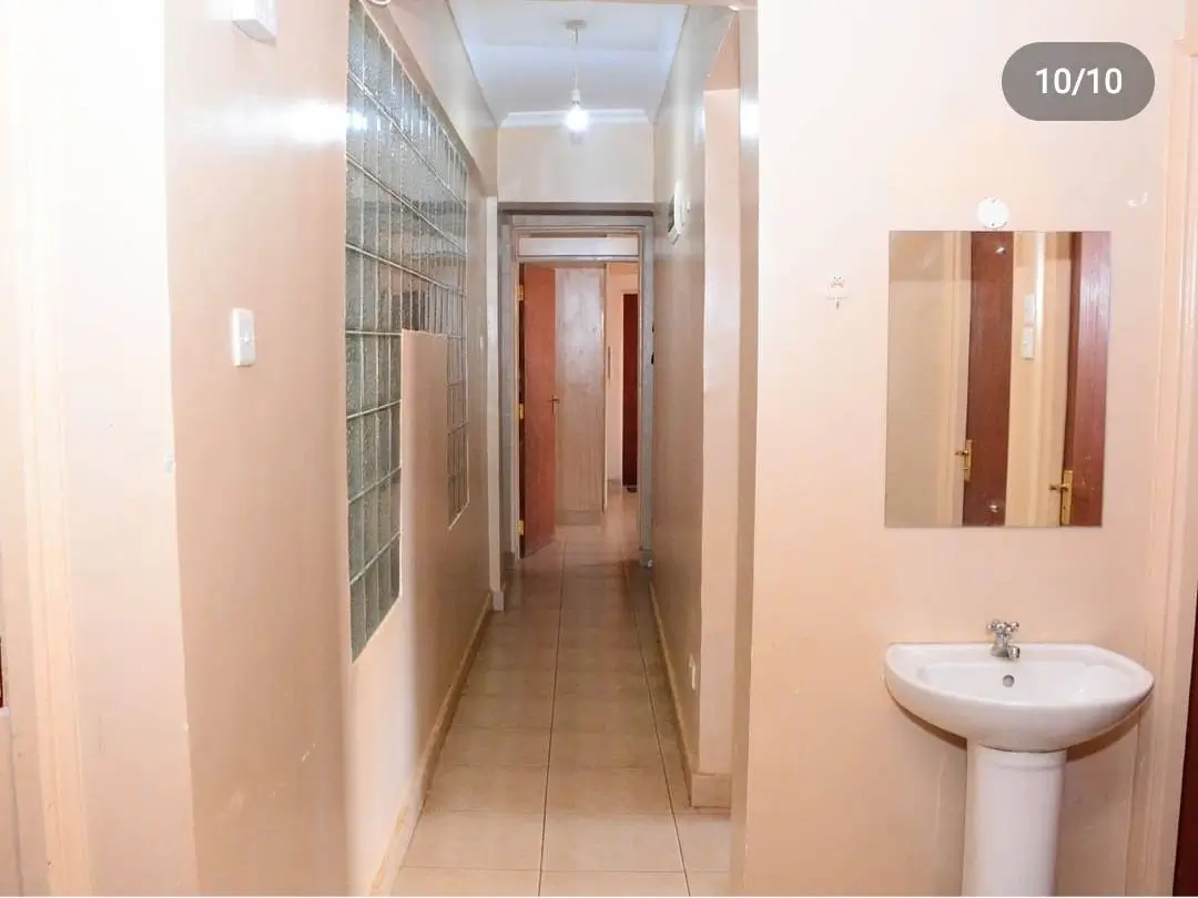 Narrow hallway with pedestal sink and storage unit
