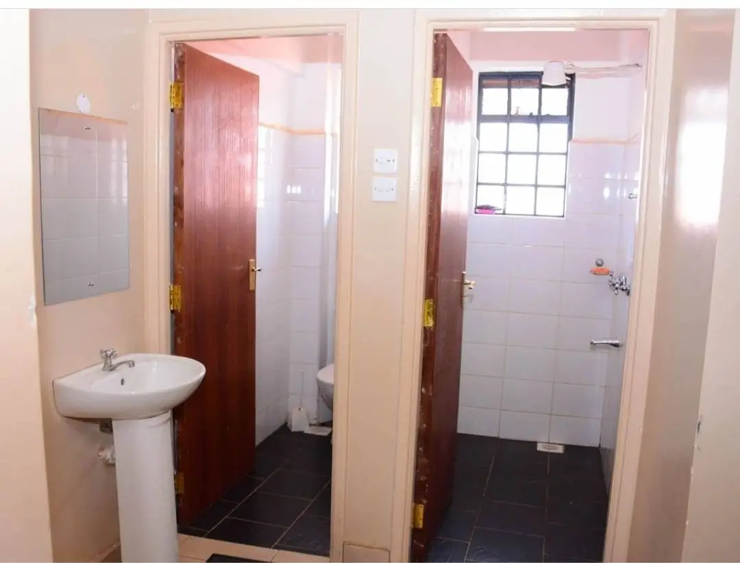 Compact bathroom with pedestal sink and shower cubicle