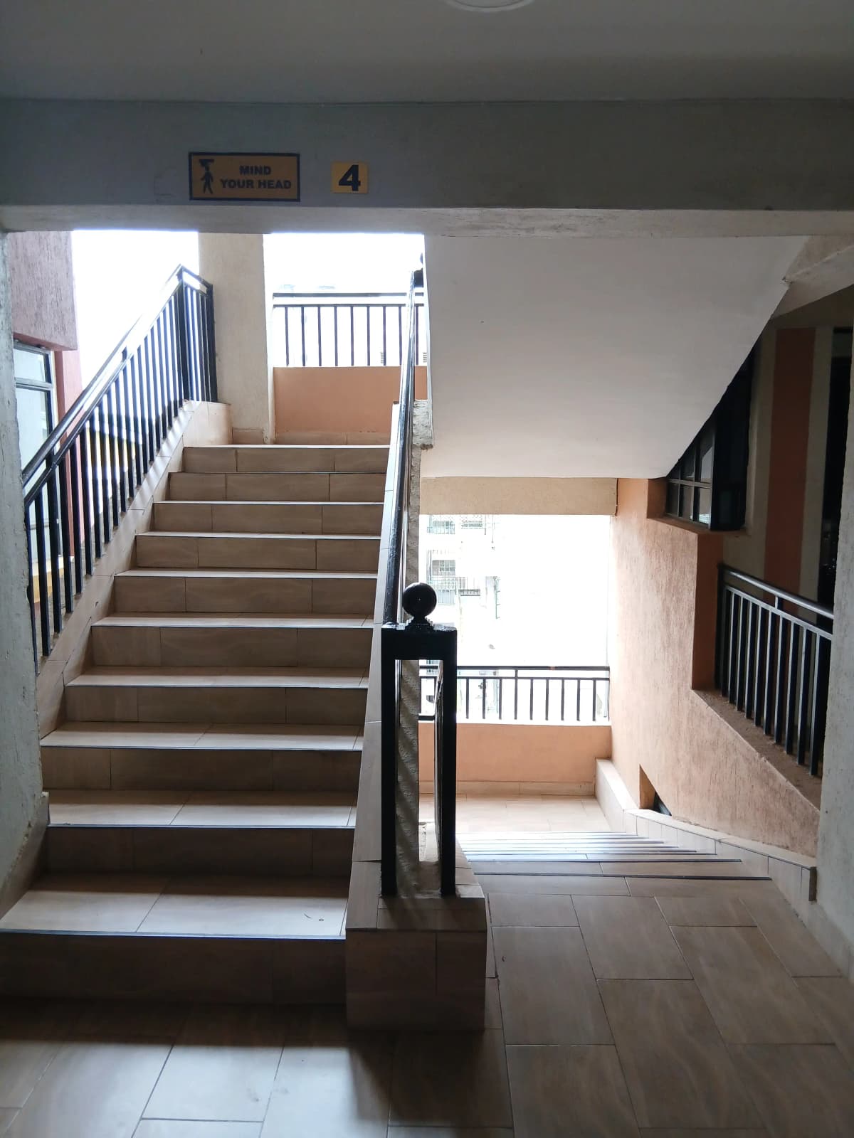 Multi-level staircase with railings and corridor access
