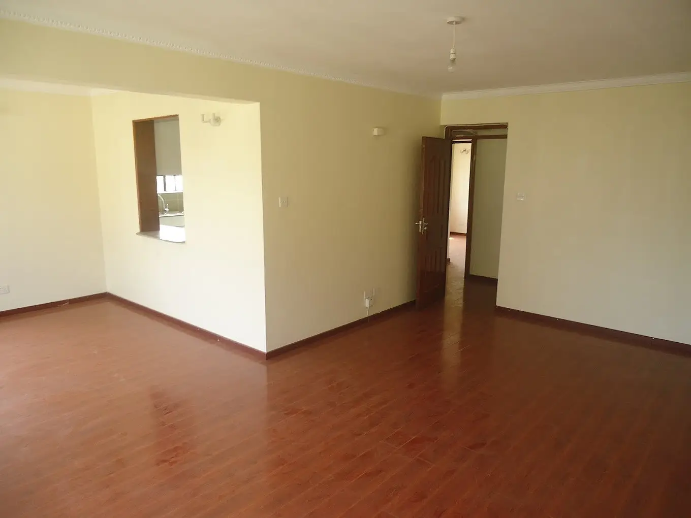 Empty living room with terracotta floor and cream walls