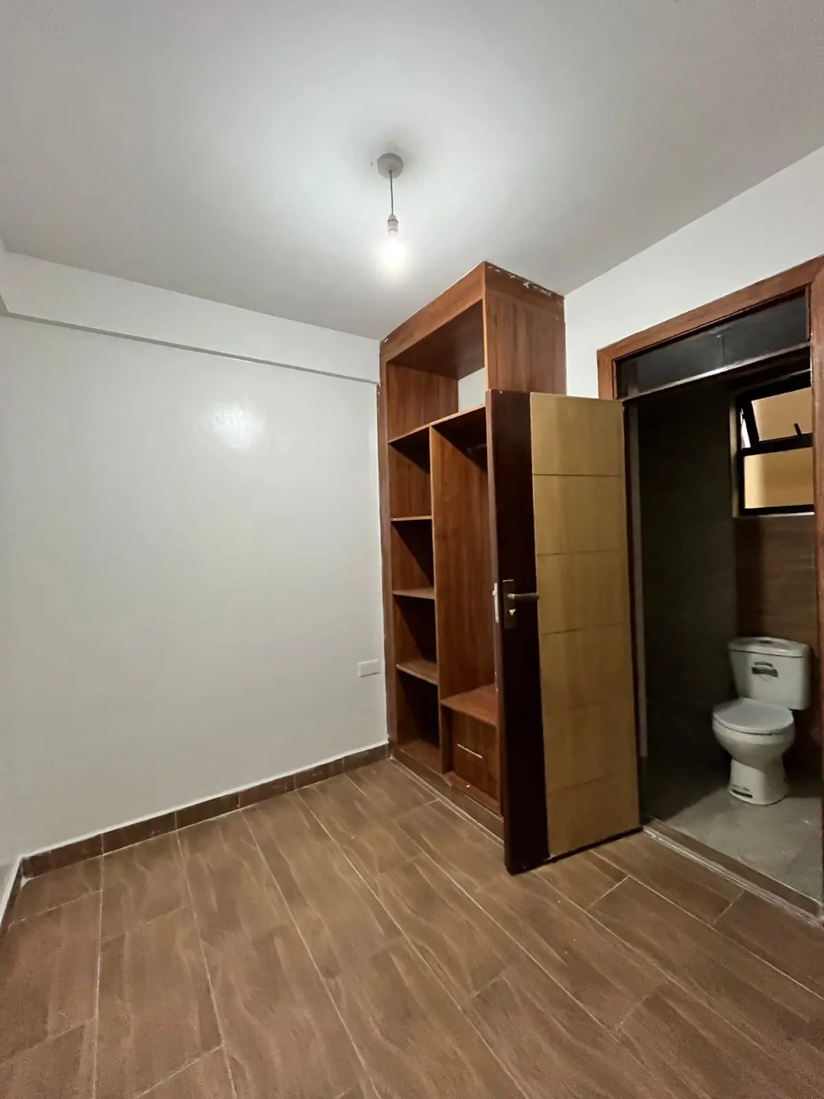Bedroom with wooden storage shelves and ensuite bathroom
