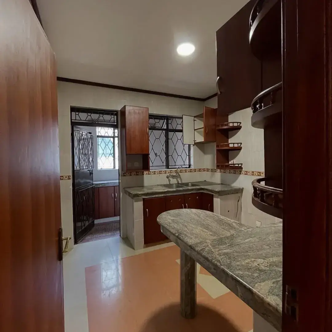 Modern kitchen with dark wood cabinetry and marble countertops