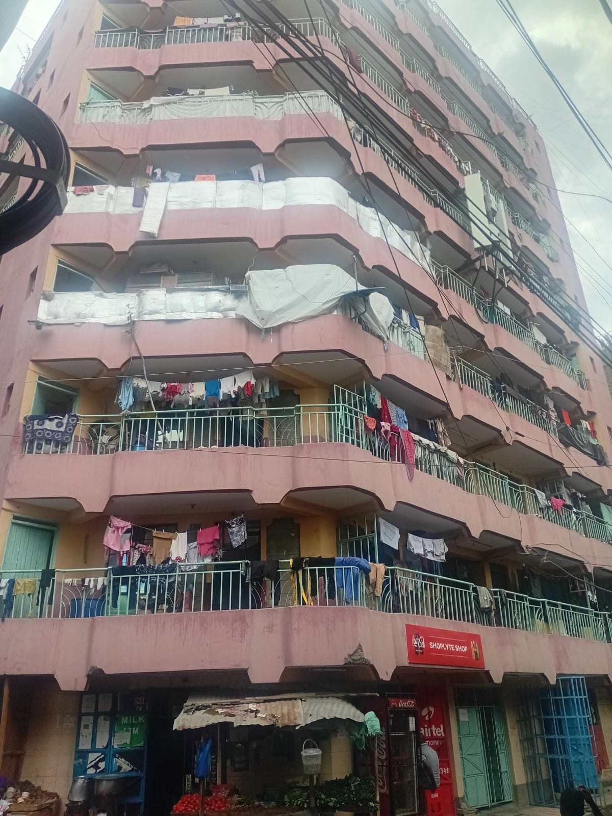 Multi-story residential building facade with balconies and ground-floor shops