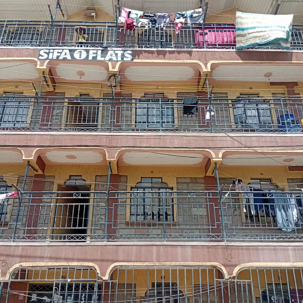 Multi-story residential building facade with balconies and signage