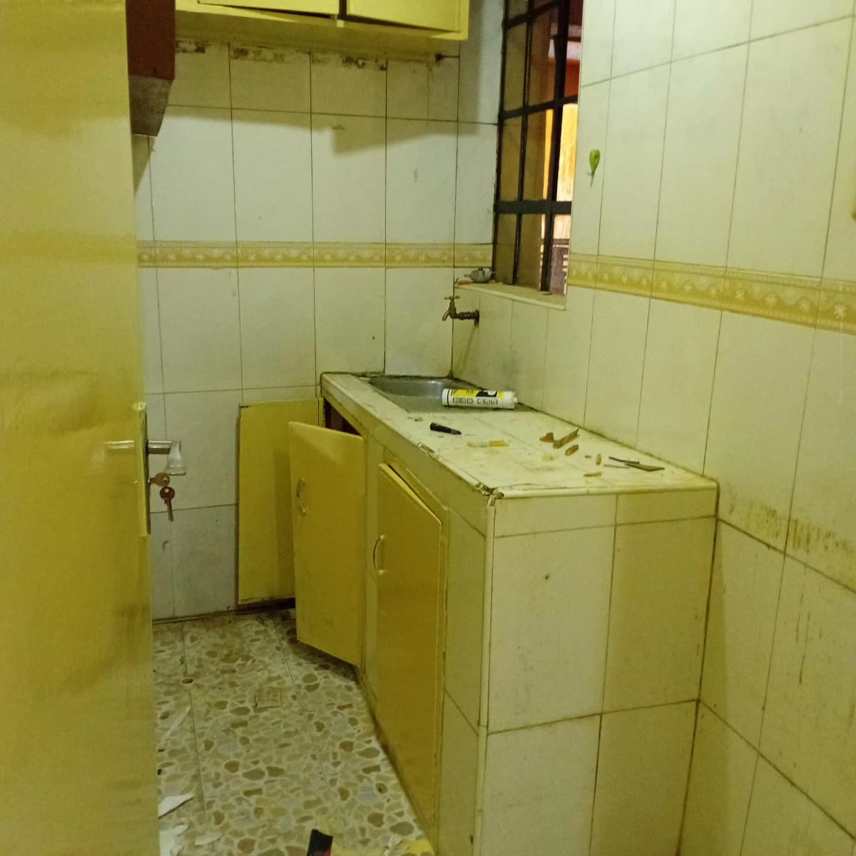 Compact bathroom with yellow cabinetry and white tile walls