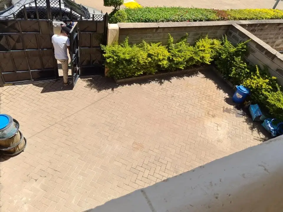 Paved compound entrance with gate and landscaped borders