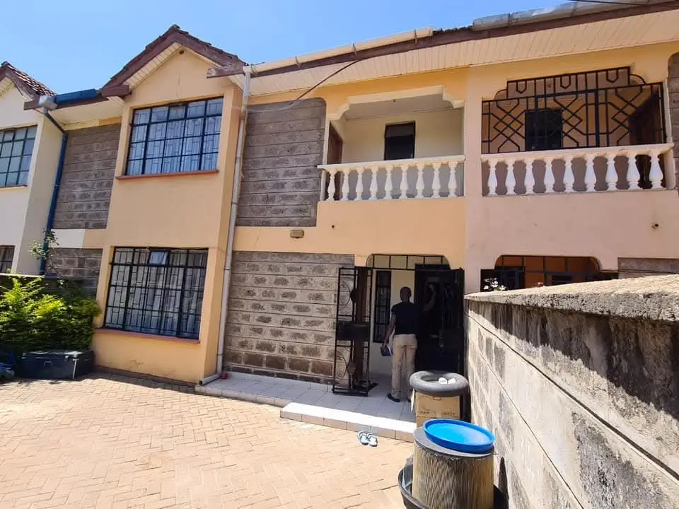 Two-story residential house with cream facade and balcony