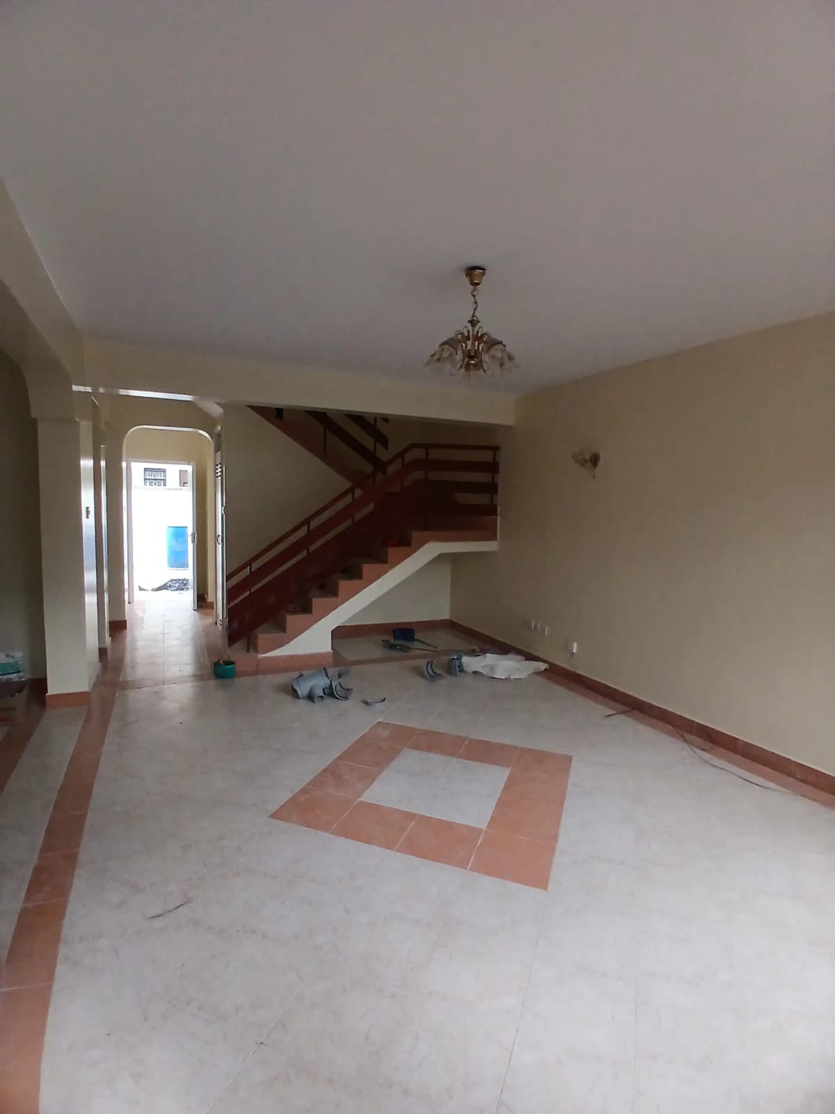 Spacious living area with staircase and geometric floor pattern