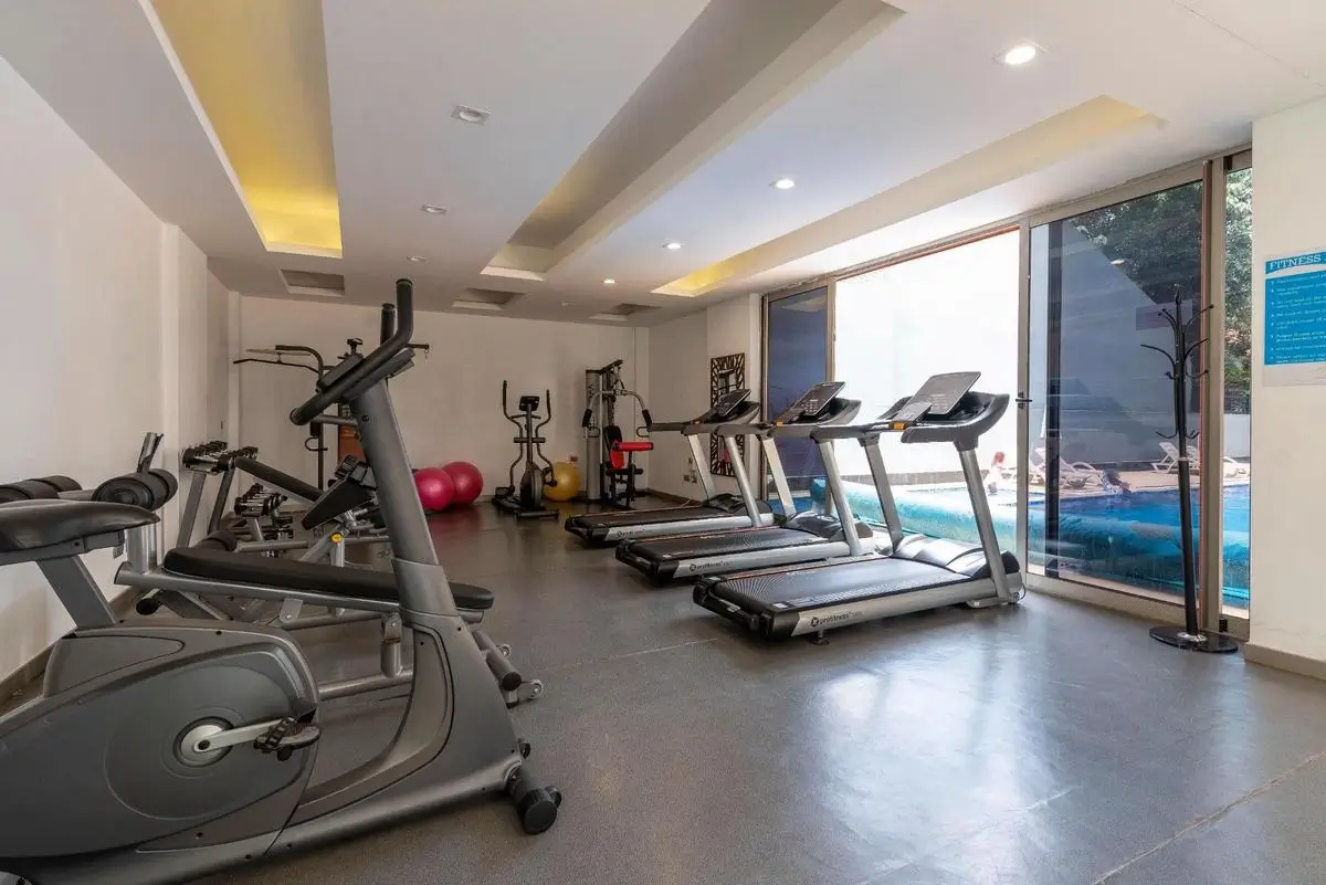 Modern gym with cardio equipment and pool view