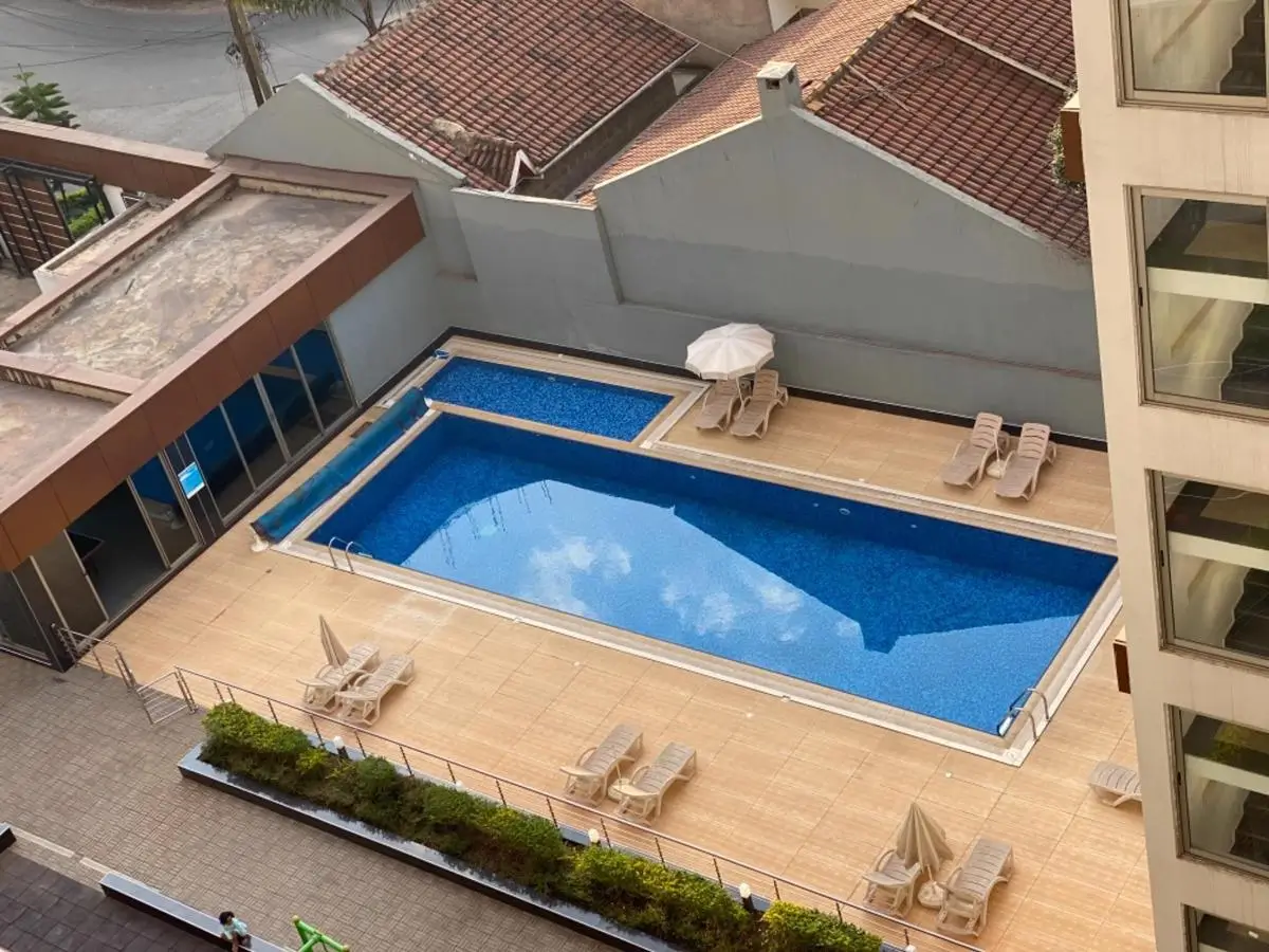 Rectangular swimming pool with blue water, deck loungers