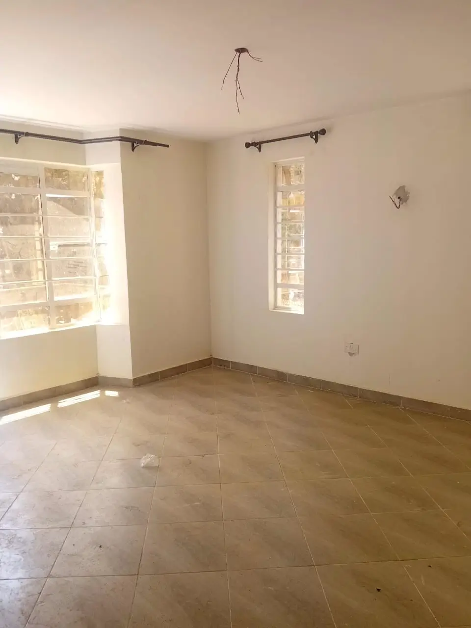 Spacious empty living room with tile flooring and natural light