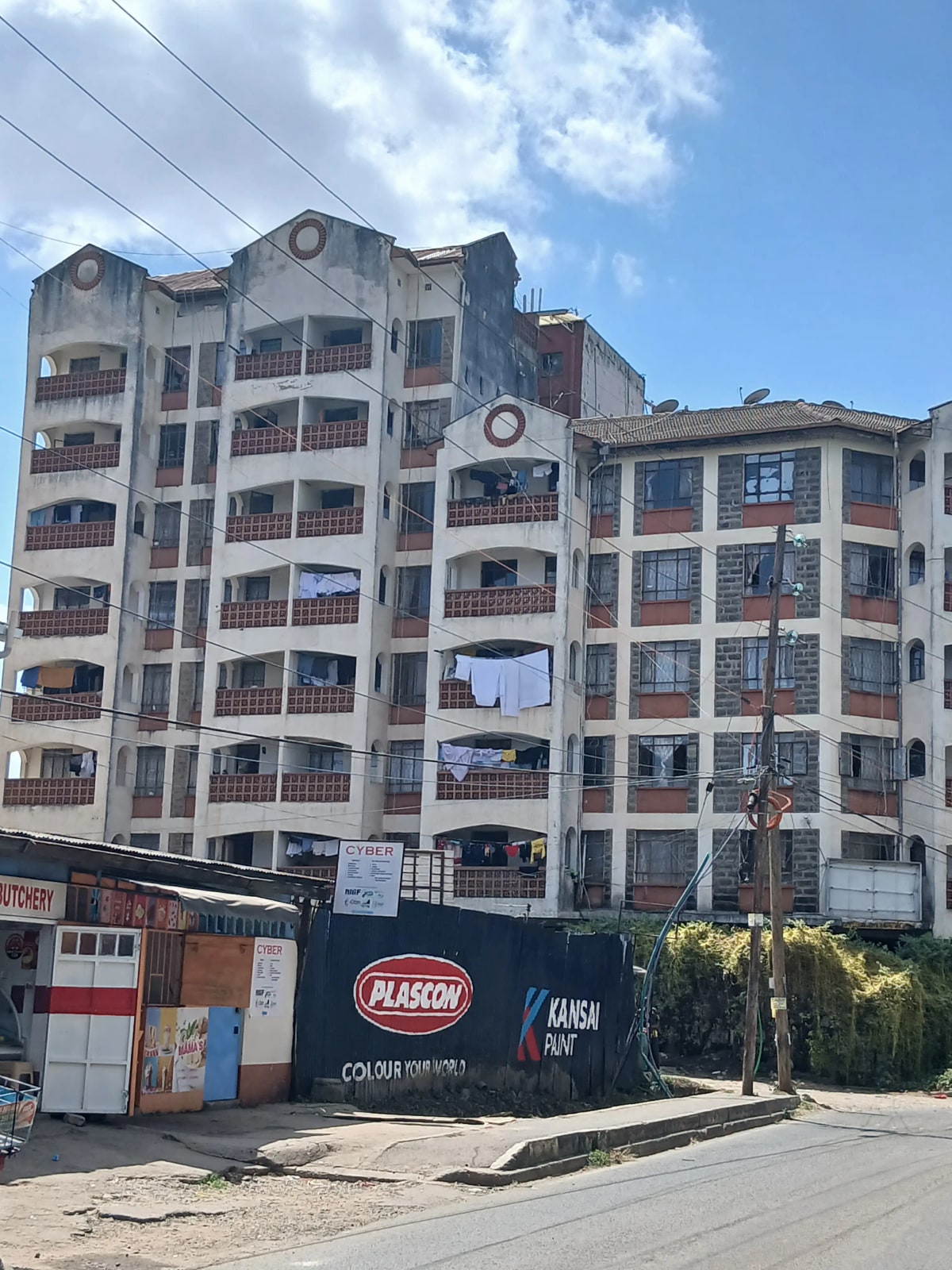 Multi-story residential building facade with balconies and street view