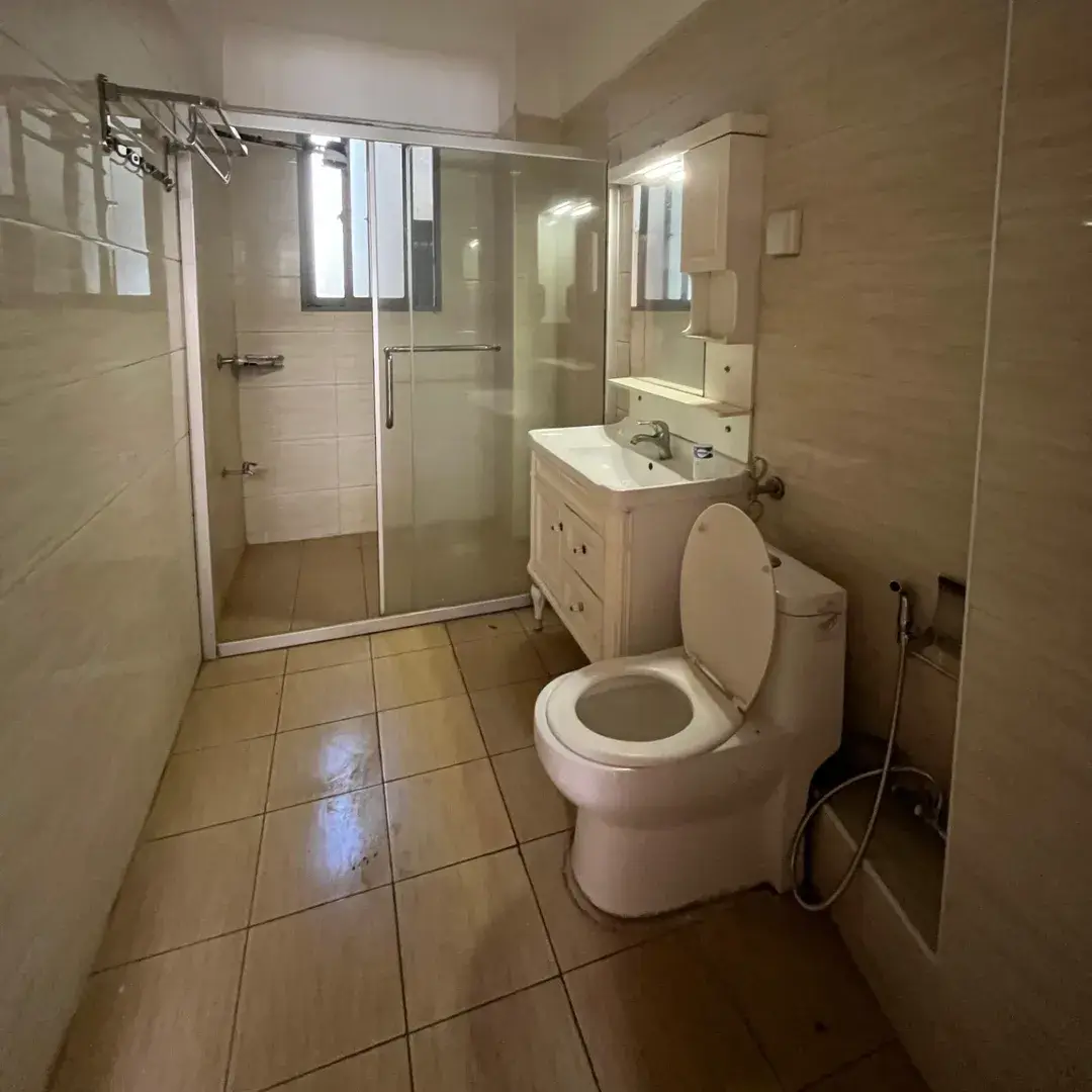 Spacious bathroom with toilet, vanity, glass shower enclosure