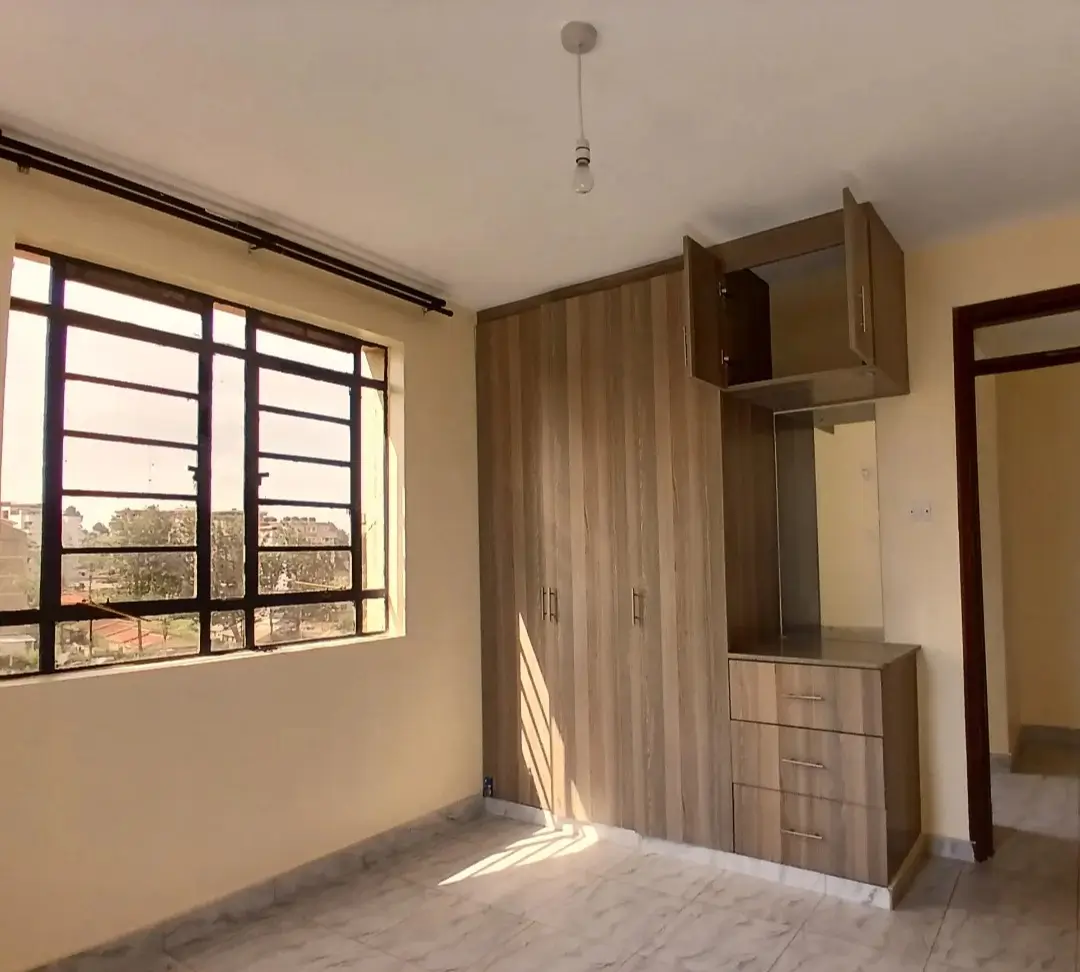 Bright bedroom with built-in wardrobe and window view