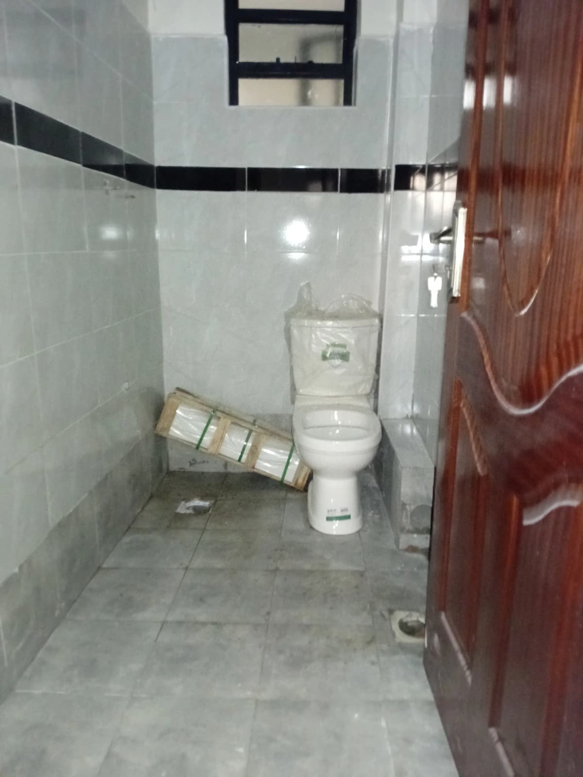 White tiled bathroom with toilet and shower area