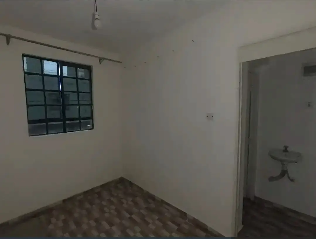 Unfurnished bedroom with barred window and tiled floor