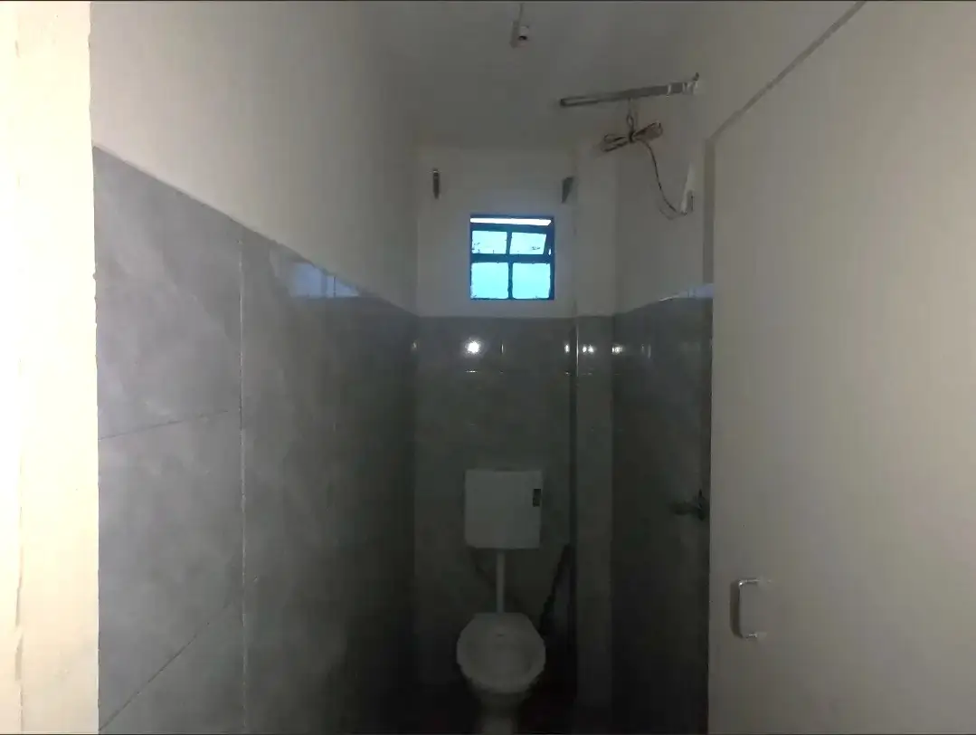 Bathroom with dark tiled walls and toilet fixture