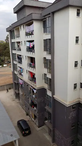 Multi-story residential building facade with balconies and street view