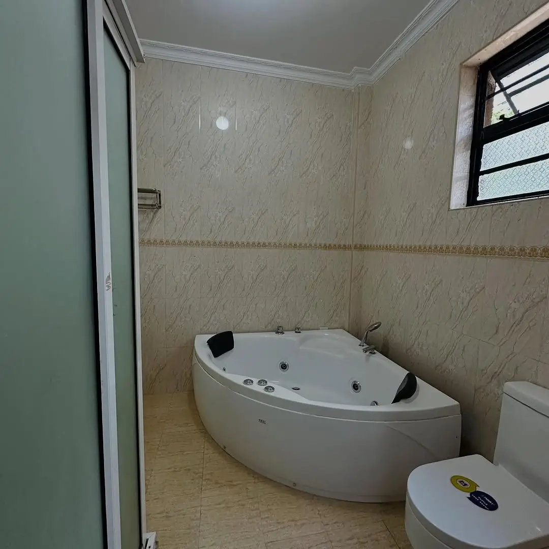 Spacious bathroom with corner jacuzzi tub and toilet