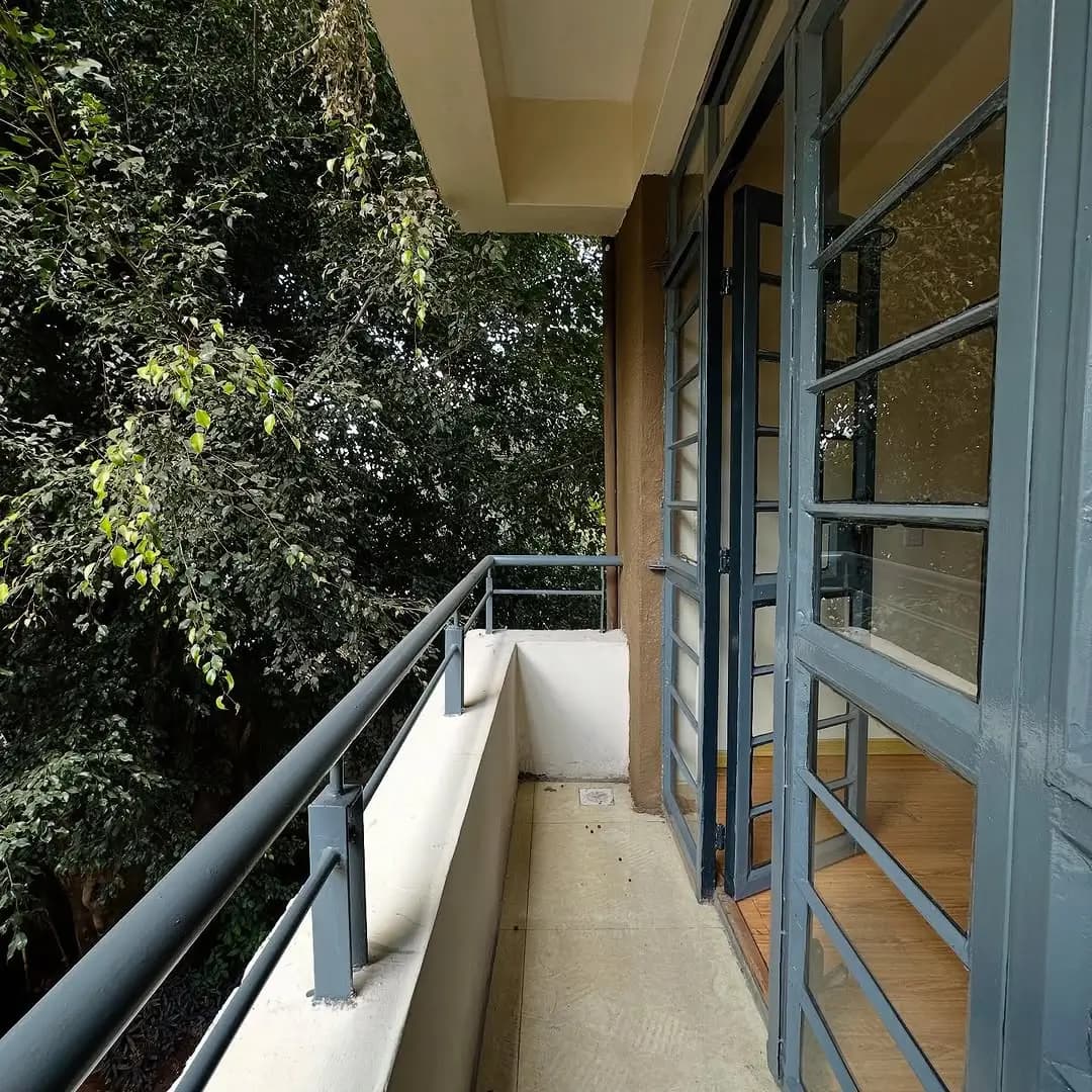 Modern balcony with metal railing overlooking lush greenery