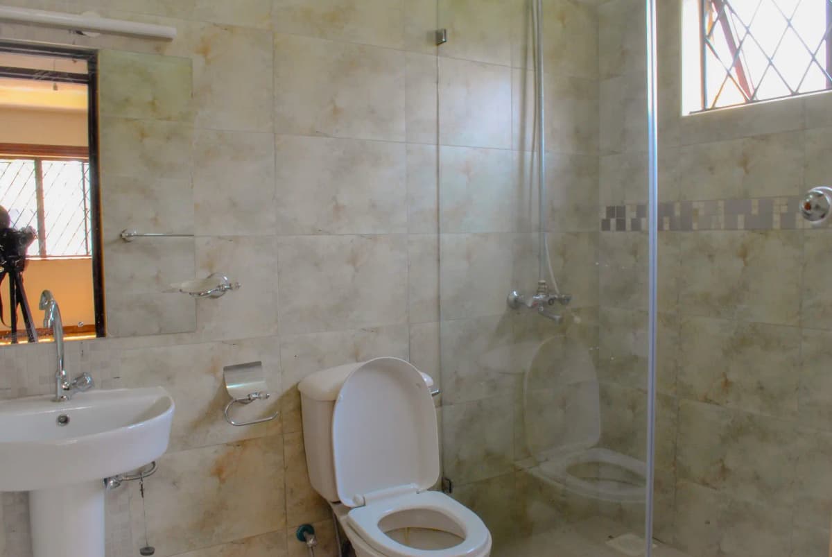 Bathroom with pedestal sink, toilet, and walk-in shower enclosure