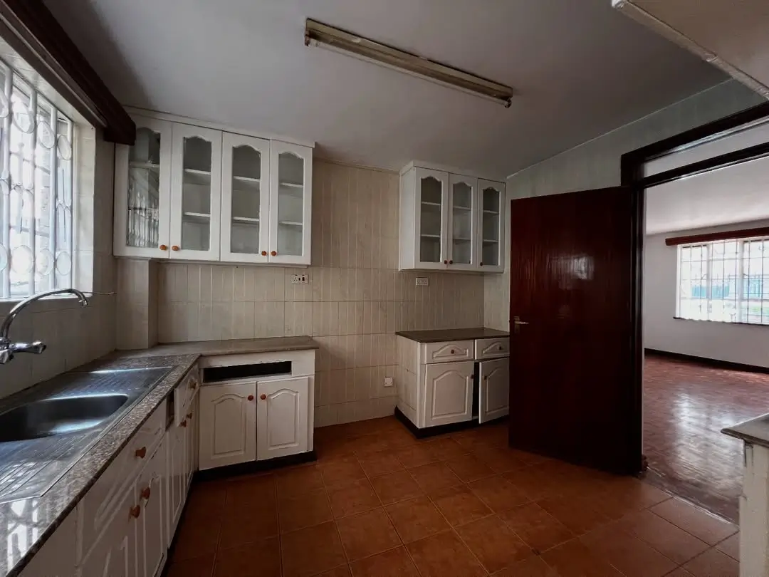 Spacious kitchen with white cabinetry and dark countertops