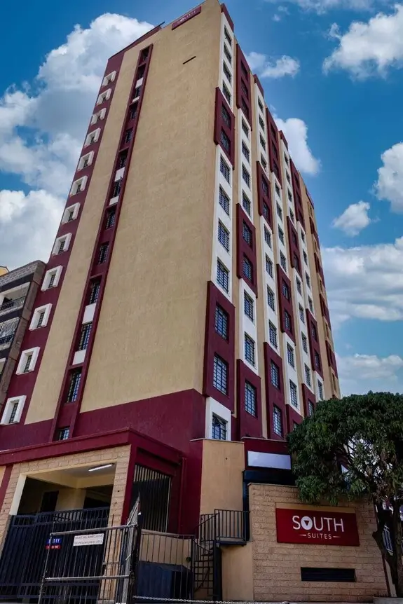 Multi-story residential building facade with burgundy and cream accents