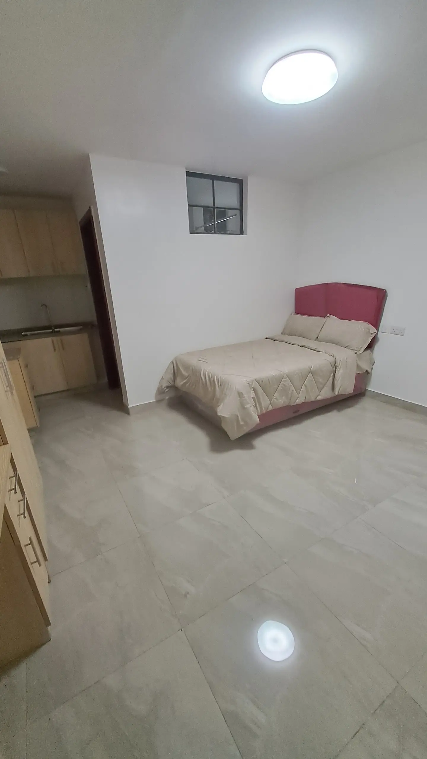 Spacious bedroom with burgundy bed frame and built-in wardrobe