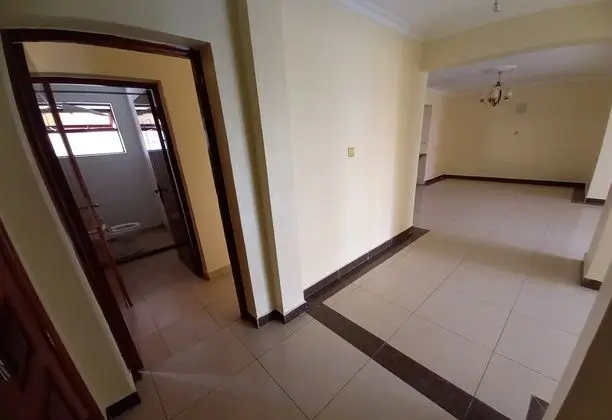 Empty corridor with tiled floors and wooden door frames