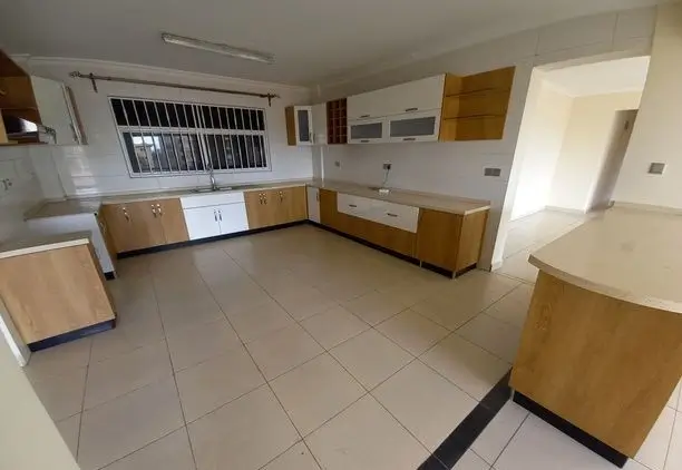 Spacious kitchen with wooden cabinetry and tiled flooring