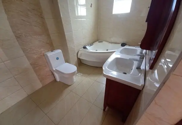 Modern bathroom with dual sinks, toilet, and soaking tub