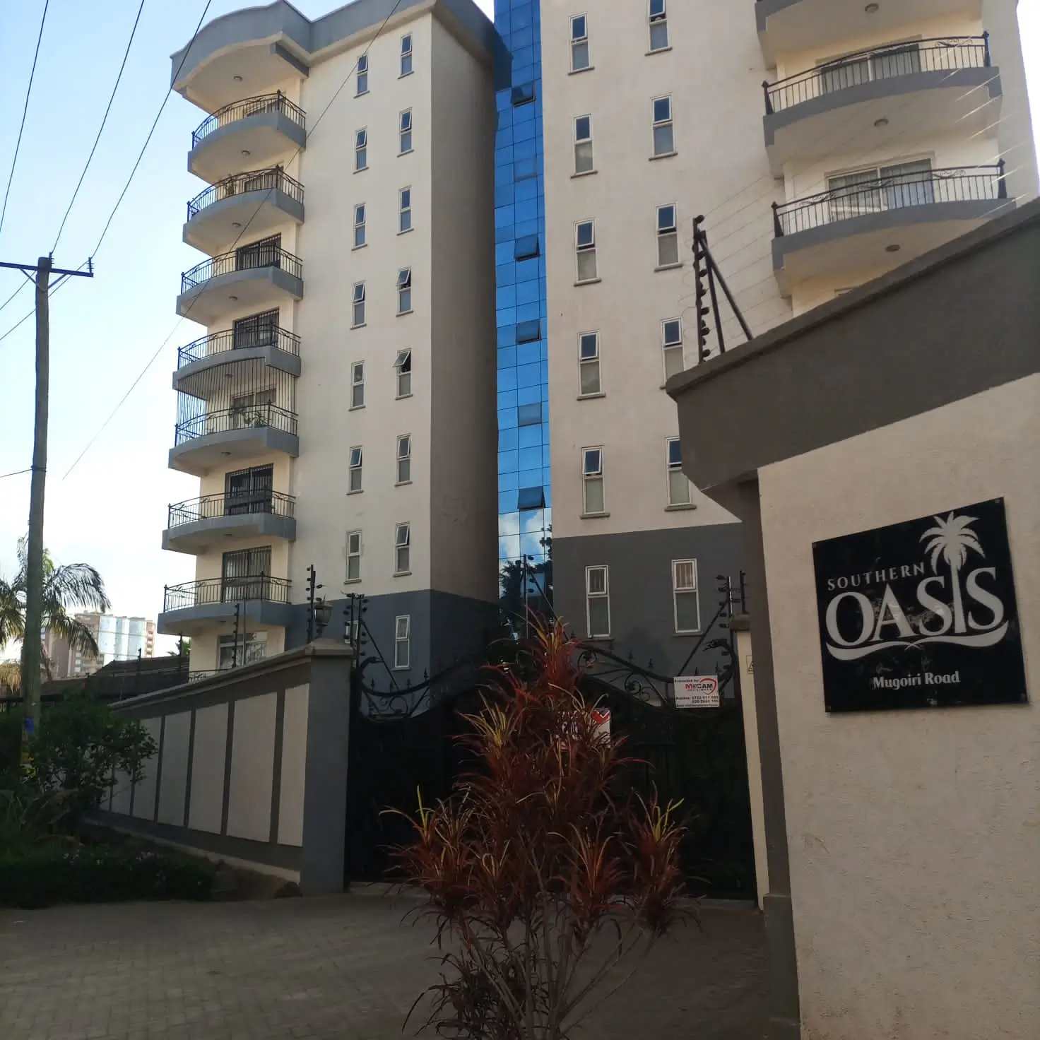 Multi-story residential building facade with balconies and entrance gate