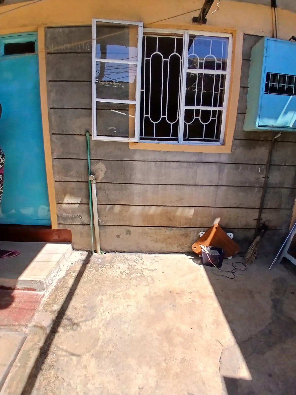 Residential compound entrance with security gate and window