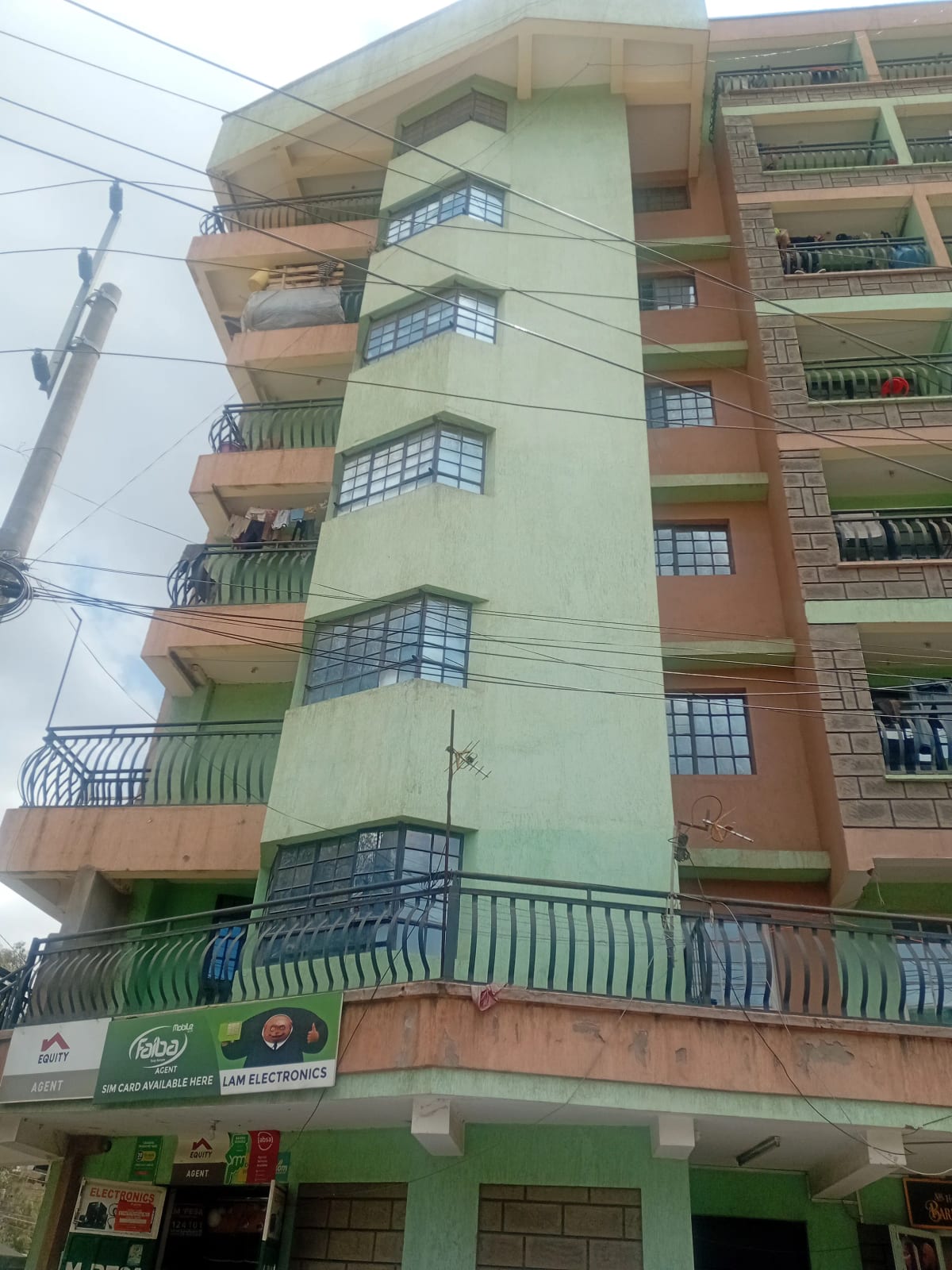 Multi-story residential building facade with balconies and retail ground floor