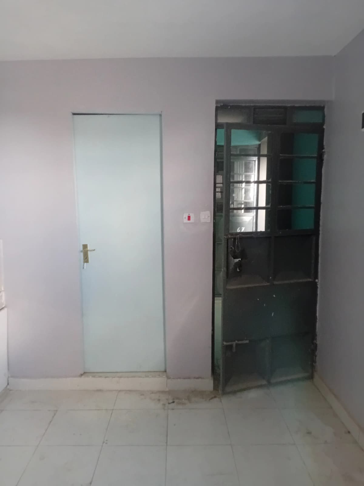 Empty corridor with two doors and tiled flooring