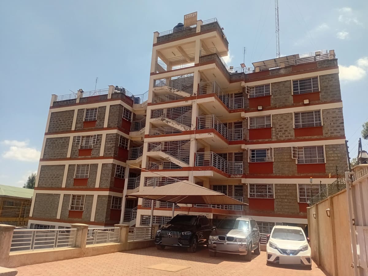 Multi-story residential building facade with ground-level parking bays