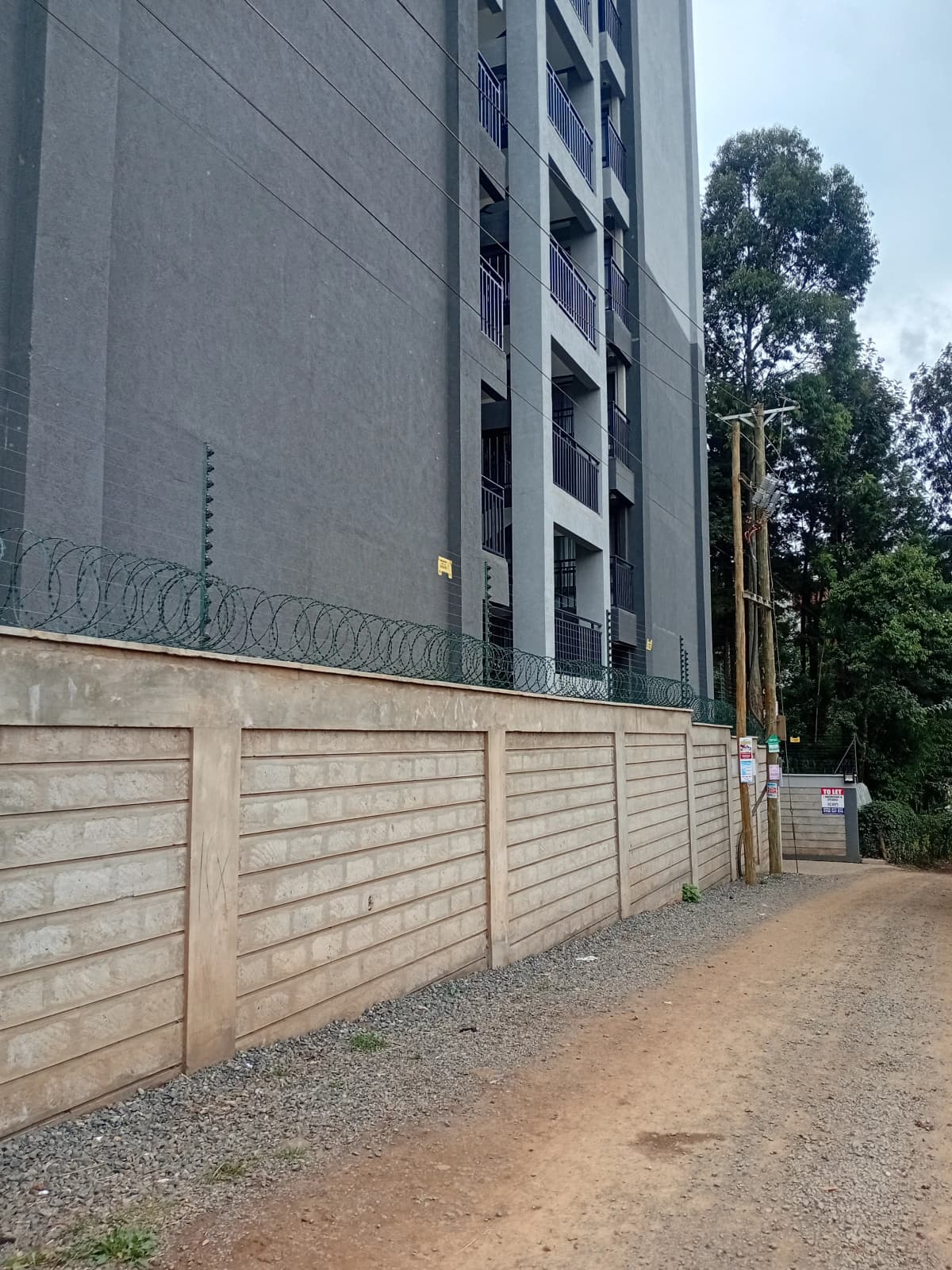 Modern apartment building with perimeter wall and gate entrance