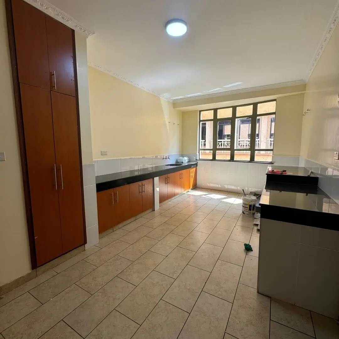 Spacious kitchen with wooden cabinets and black countertops