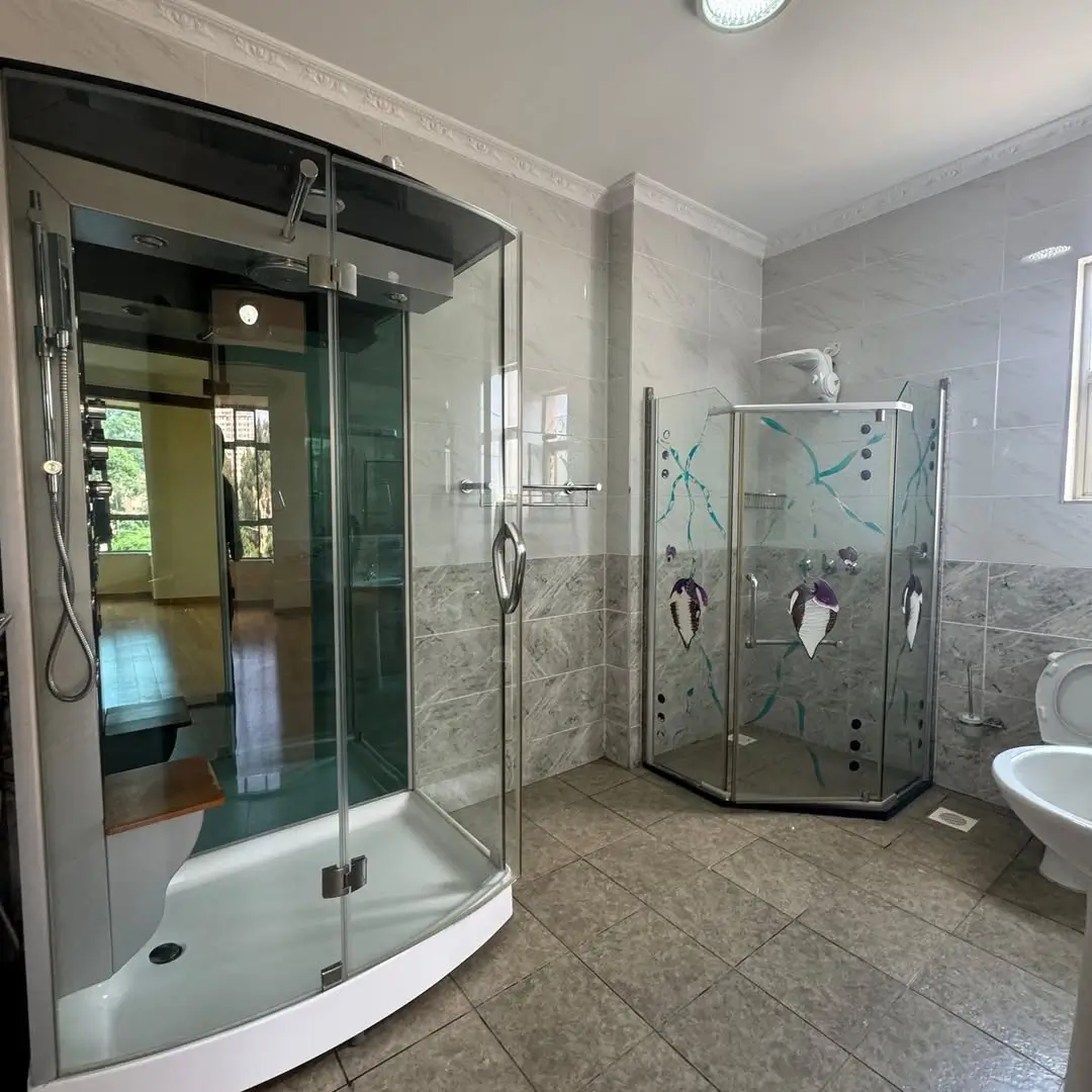 Spacious bathroom with dual shower enclosures and marble tiling