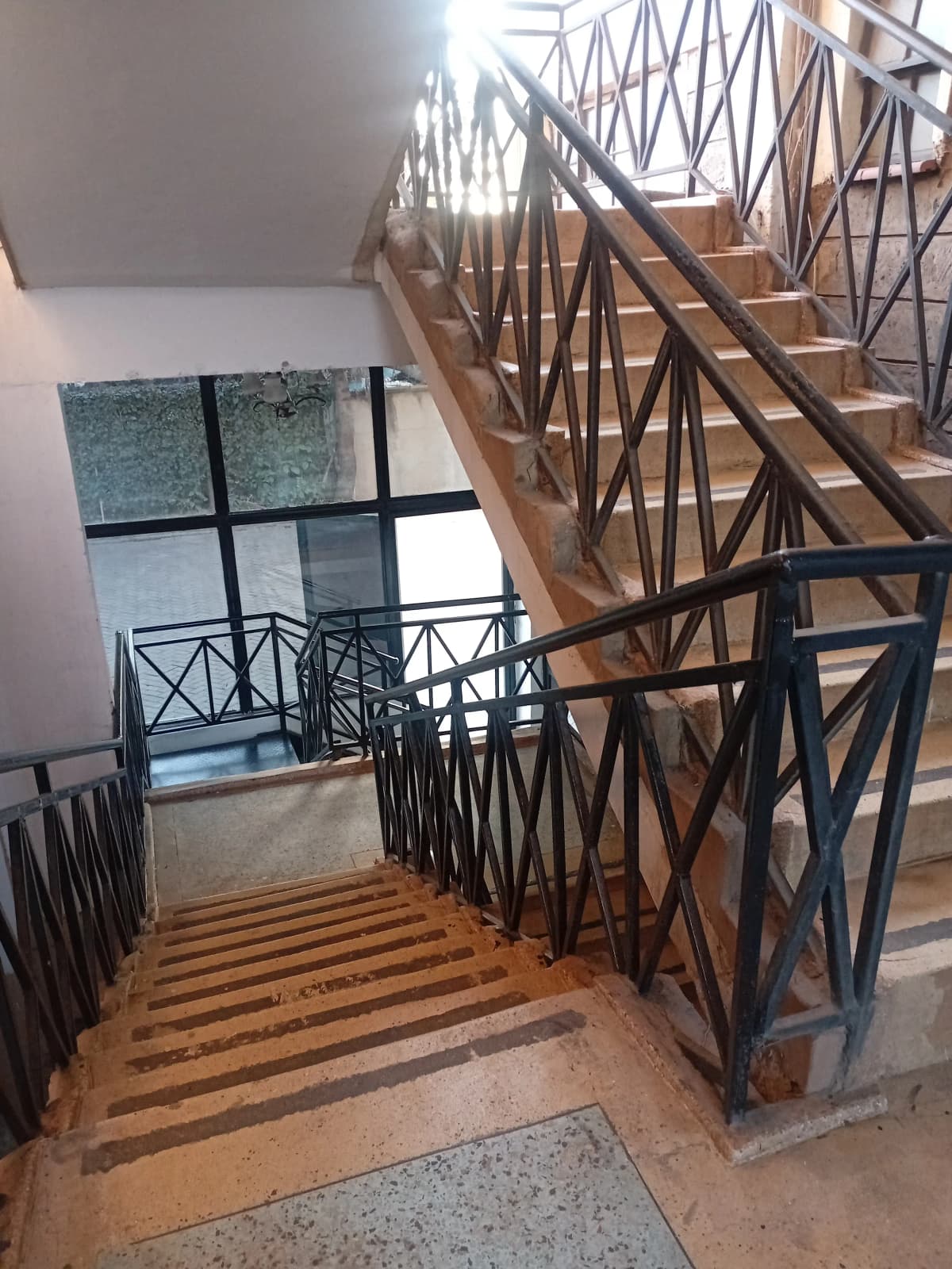 Modern staircase with black metal railing and wooden steps
