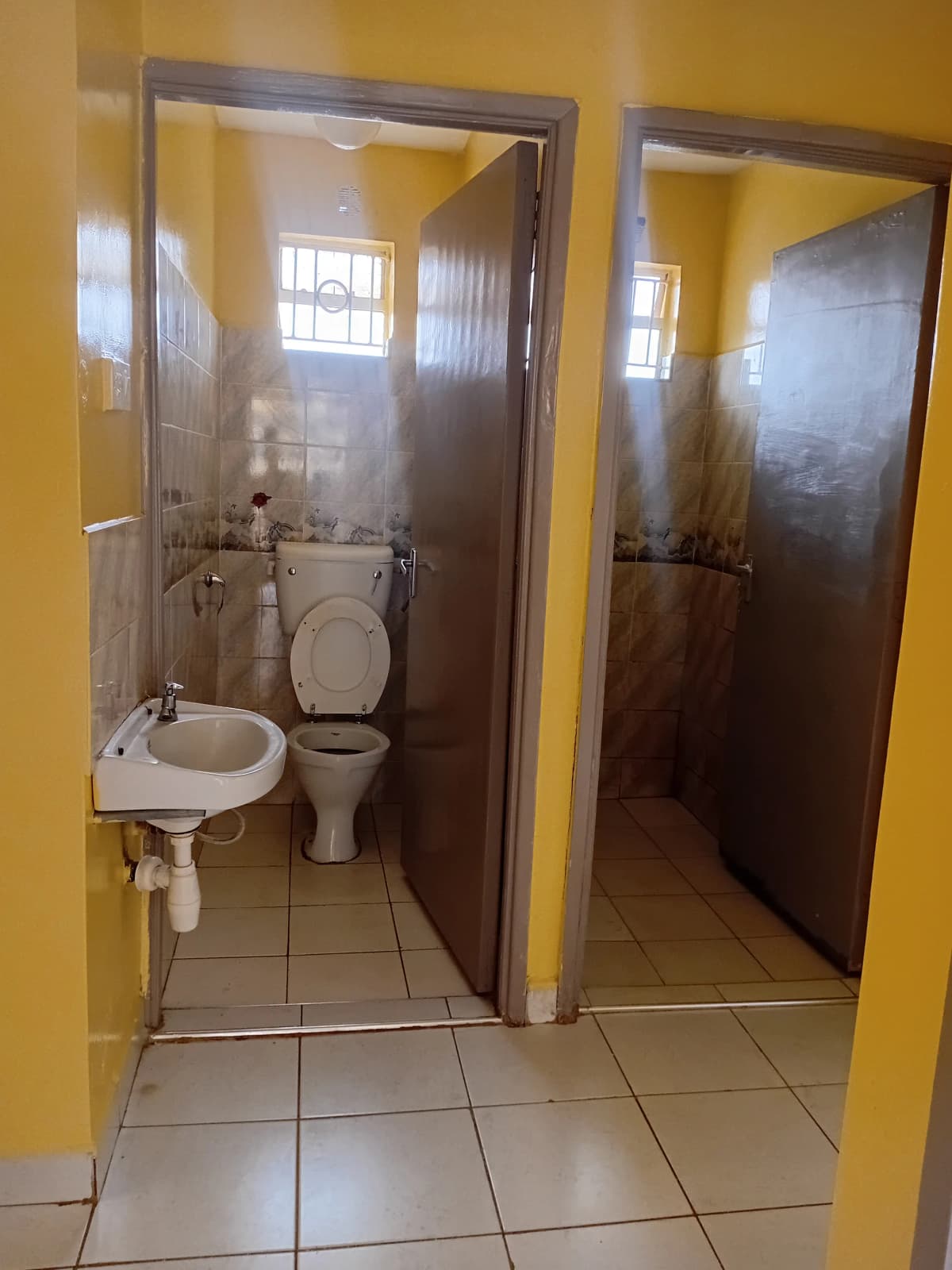 Compact bathroom with toilet, sink, and shower cubicle