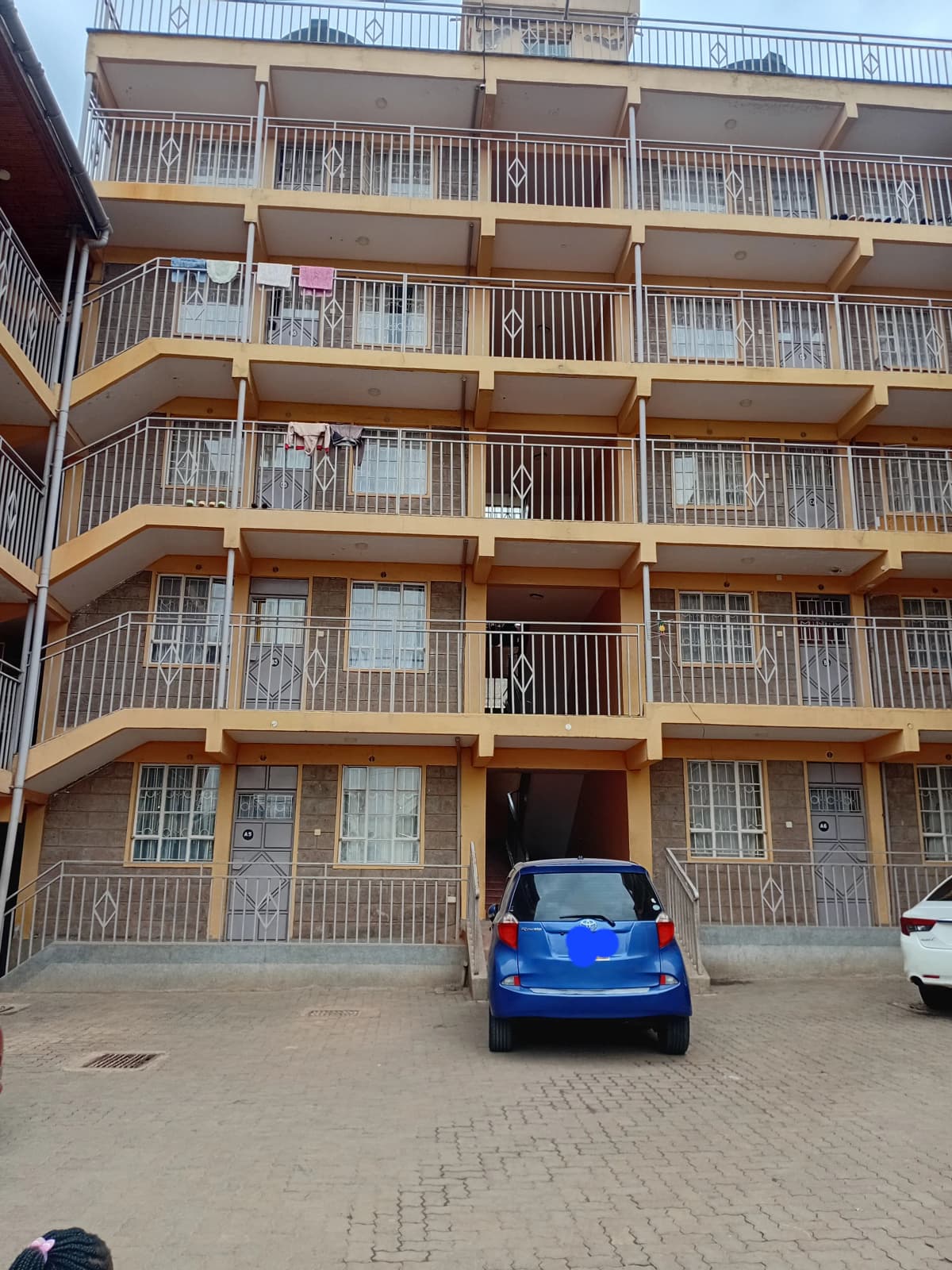 Multi-story residential building facade with ground-level parking bay