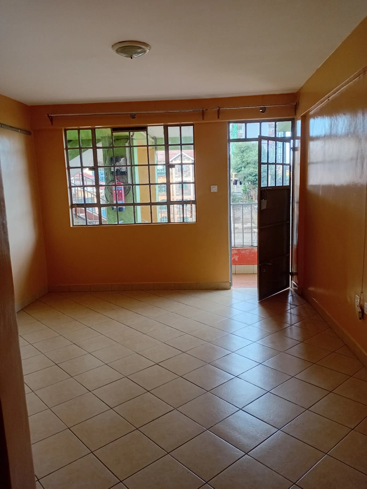 Spacious living area with terracotta walls and tile flooring
