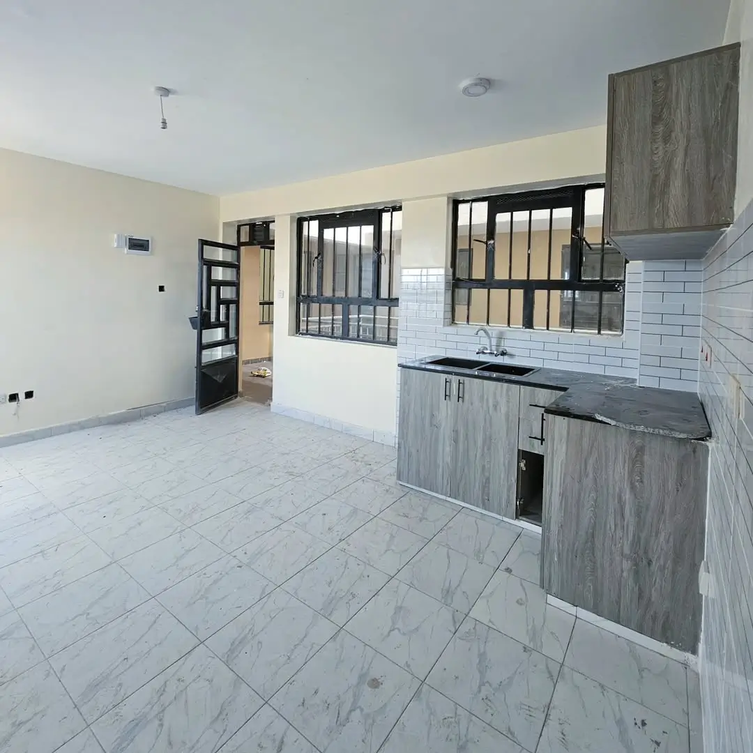 Open-plan kitchen with gray cabinetry and white subway tile