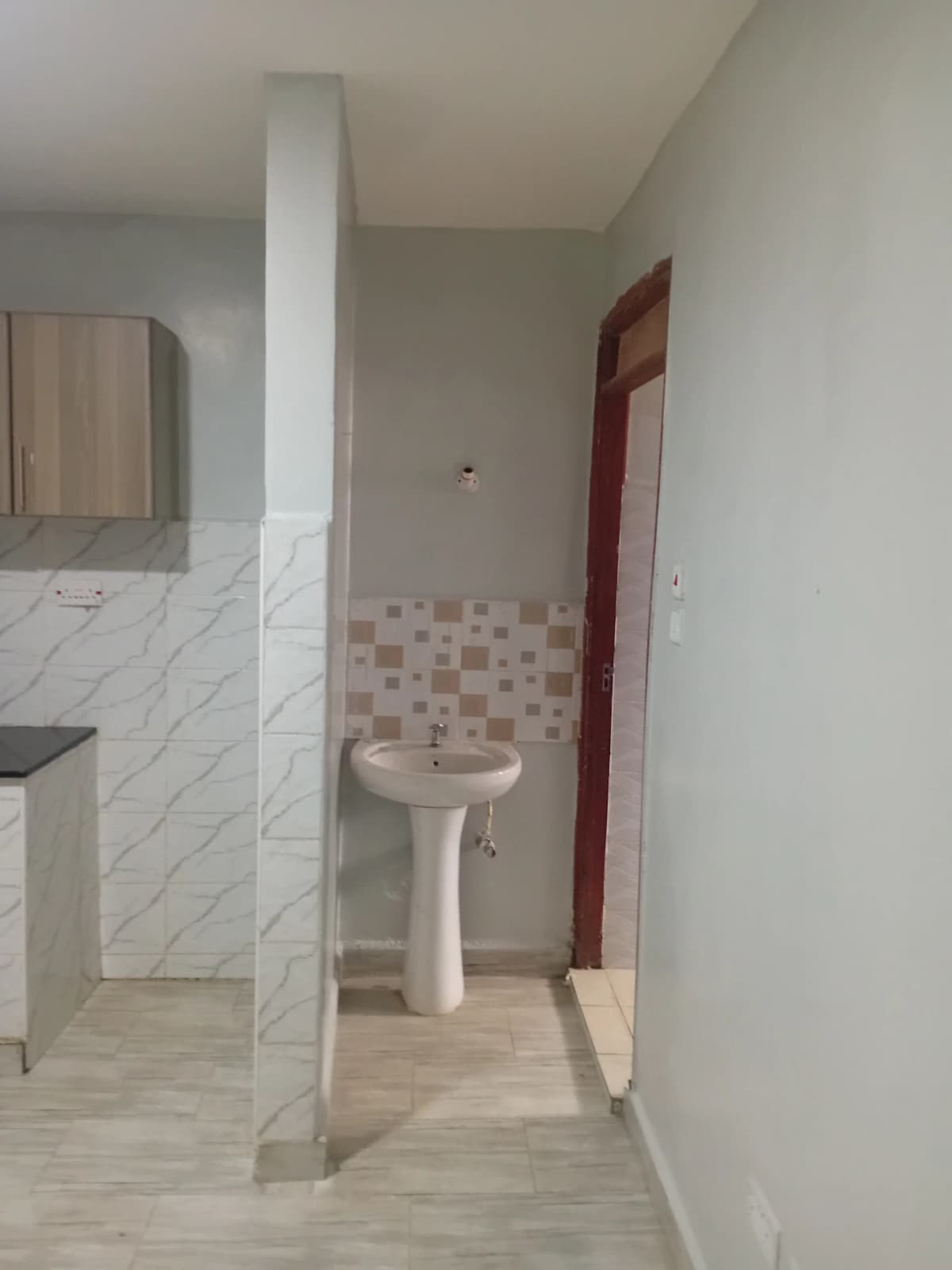 Bathroom with white sink vanity and tiled walls.