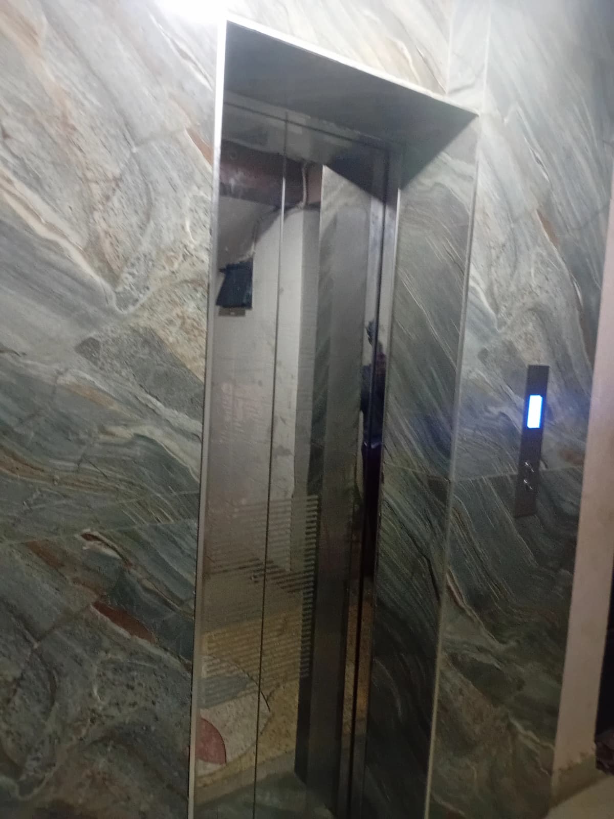 Building corridor with marble flooring and overhead lighting