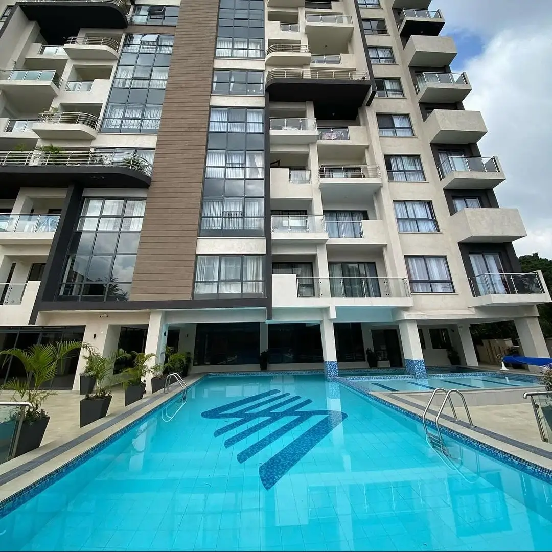 Resort-style swimming pool with lane markings, modern apartment building backdrop