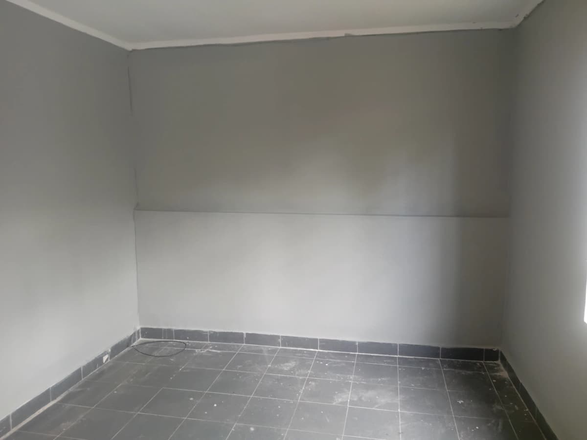 Empty room with dark tile flooring and plain walls