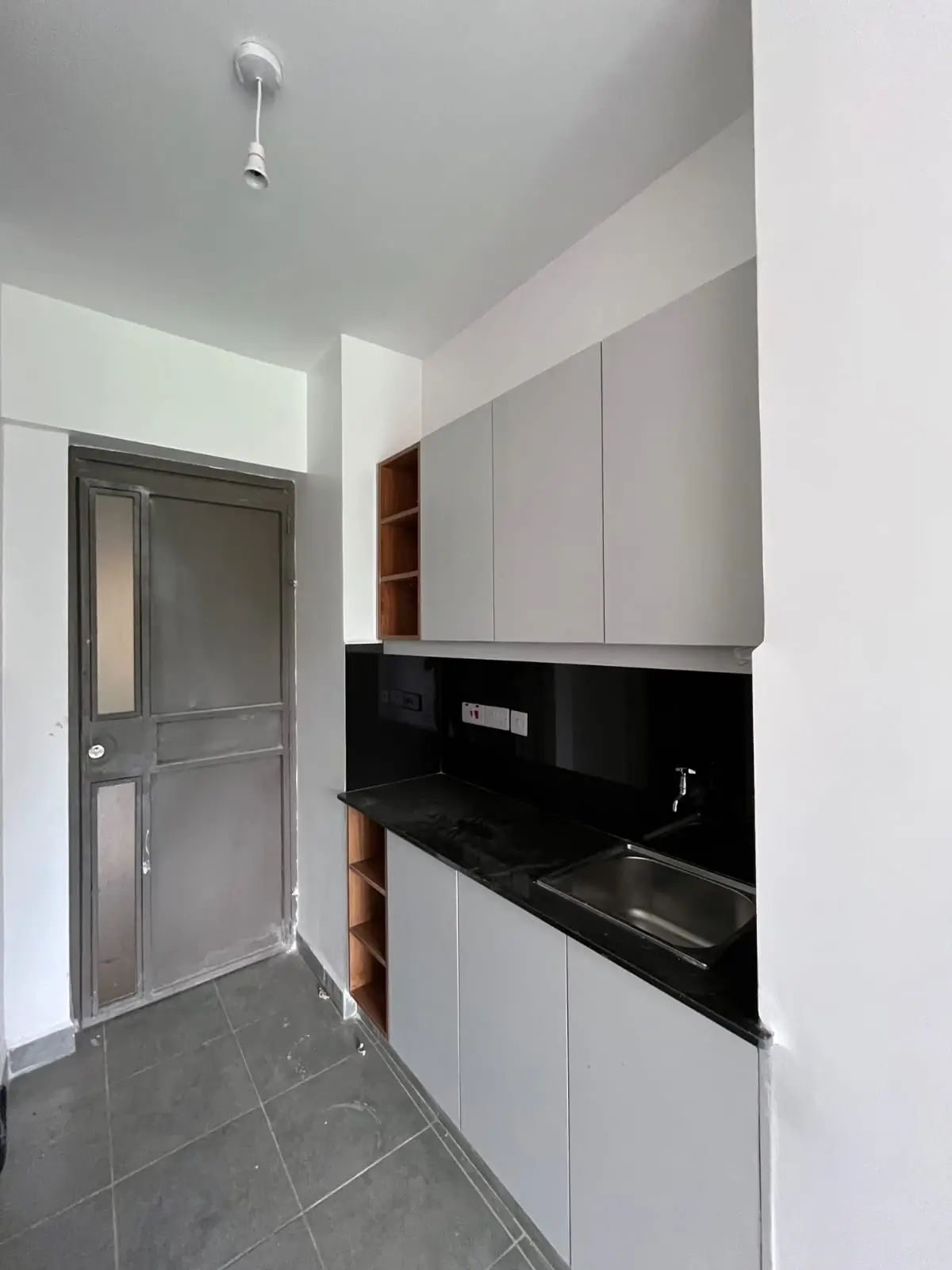 Modern galley kitchen with white cabinetry and black backsplash